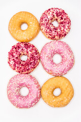 Variety of tasty donuts with vibrant pink glaze, sprinkles, and sugar coating, isolated on white — sweet treat ideal for food photography, bakery ads, and dessert lovers