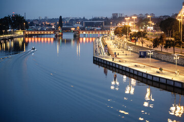 Illuminated riverside promenade in Szczecin at dusk, Poland