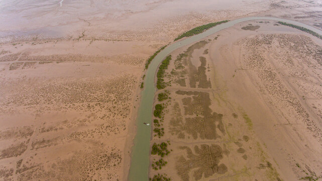 Aerial view of serpentine mangroves and wetlands with a river, Keti Bander, Sindh, Pakistan.