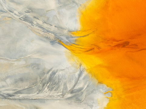Aerial view of vibrant abstract forms and color patterns in a serene landscape, El Campillo, Huelva, Spain.
