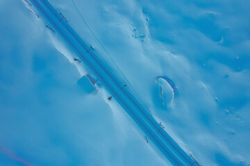 Aerial view of majestic snow-covered mountains with a serene rail track, Zermatt, Valais, Switzerland.