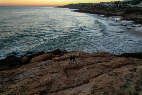 Aerial view of beautiful beach with serene ocean, rocky cliffs, and picturesque coastline, Algave, Portugal.