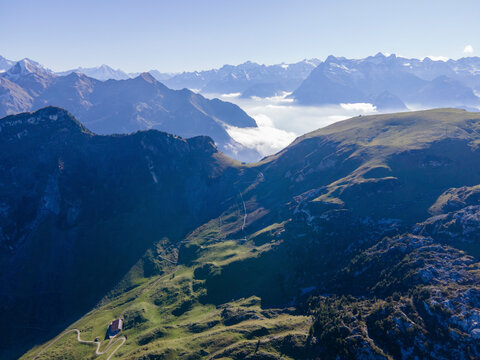 Aerial view of majestic snow-capped mountains and a tranquil valley under a clear sky, Stoos, Schwyz, Switzerland.