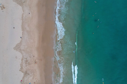 Aerial view of beautiful beach with serene waves and clear blue water, Algave, Portugal.