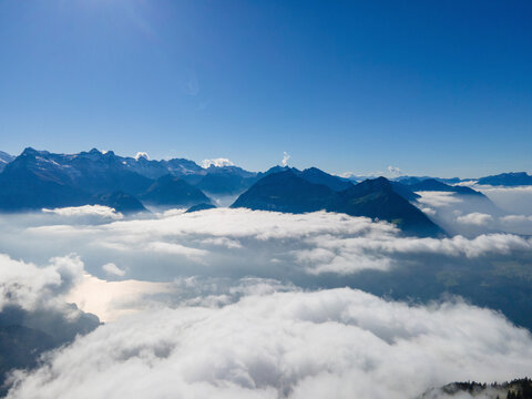 Aerial view of majestic snow-covered mountains and clouds, Stoos, Schwyz, Switzerland.