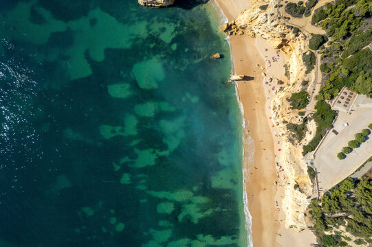 Aerial view of beautiful beach with clear water and scenic cliffs, Algave, Portugal.