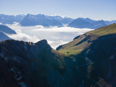 Aerial view of majestic snow-capped mountains with dramatic clouds and a serene sky, Stoos, Schwyz, Switzerland.