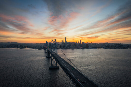 Aerial view of bay bridge and yerba buena island at sunset with beautiful cityscape and skyline, San Francisco, California, United States.