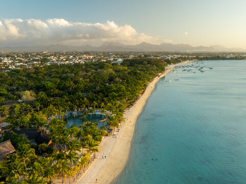 Aerial view of tranquil tropical beach with palm trees and white sand shoreline, Trou aux Biches, Pamplemousses, Mauritius.