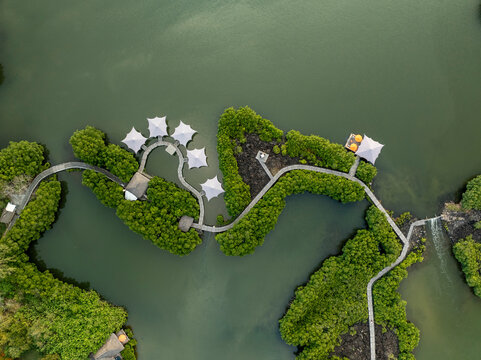 Aerial view of serene lake surrounded by lush greenery and tents, Prince Maurice, Flacq, Mauritius.