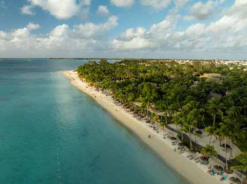 Aerial view of tranquil Trou aux Biches beach with palm trees and clear water, Pamplemousses, Triolet, Mauritius.