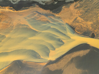 Aerial view of beautiful glacial river with vibrant patterns and serene landscape, Hvolsvollur, Southern Region, Iceland.