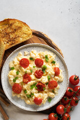 Scrambled eggs with onion and tomatoes on plate