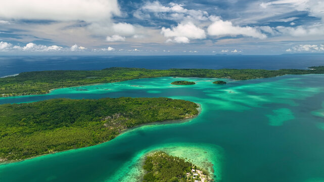 Aerial view of a beautiful tropical island with clear blue water and lush vegetation, Western Province, Solomon Islands.