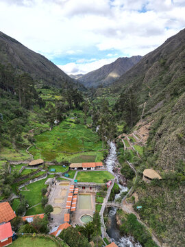 Aerial view of lares hot spring village nestled in a lush valley surrounded by mountains and greenery, Lares District, Cusco, Peru.