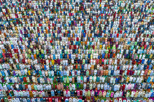 Shibganj, Bangladesh - 10 July 2022: Aerial view of a colorful eid prayer gathering with a multitude of people in devotion, Mokamtala, Shibganj, Rajshahi, Bangladesh.