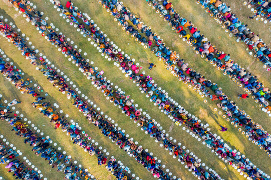 Aerial view of a colorful congregation during a majlis public food offering on grass, Shibganj, Rajshahi, Bangladesh.