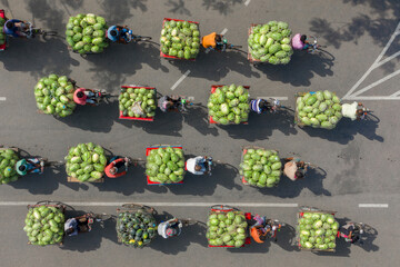 Aerial view of wholesale watermelon market bustling with people and bicycles, Roynagar, Rajshahi, Bangladesh.