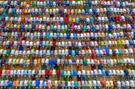 Aerial view of colorful congregation of people during Eid Prayer with prayer mats arranged in rows, Bogura, Rajshahi, Bangladesh.