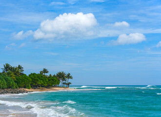 Fototapeta premium Koggala beach with blue cloudy sky and foamy waves, Koggala, Sri Lanka, Asia
