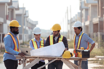 Group of architects and engineers work together to assess the residential home construction site's...