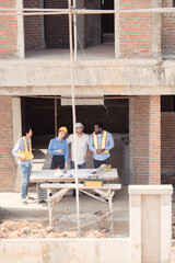 Fototapeta premium Group of architects and engineers work together to assess the residential home construction site's progress