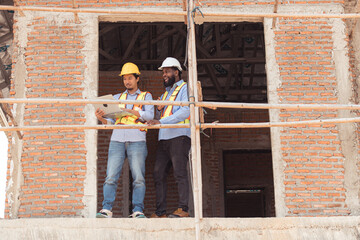 Architects and engineers work together to assess the residential home construction site's progress