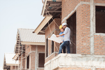 Architects and engineers work together to assess the residential home construction site's progress