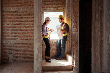Architects and engineers work together to assess the residential home construction site's progress