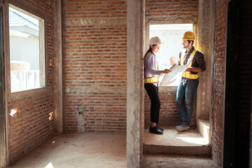 Fototapeta premium Architects and engineers work together to assess the residential home construction site's progress