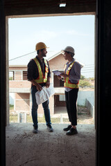 Fototapeta premium Architects and engineers work together to assess the residential home construction site's progress
