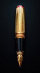 Golden pen with a red gem cap and detailed carvings on the tip on a dark background