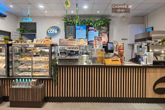 Penang, Malaysia - Mar 26, 2025: Interior view of Shell Caf&eacute; at a Shell petrol station featuring a modern counter, pastry display, and coffee machine setup, offering fresh pastries and hot drinks.