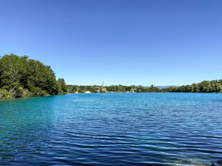 Calm blue lake with trees in the background