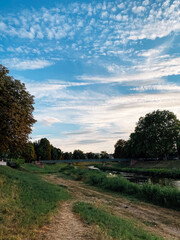 Path runs through a grassy area with a river running alongside it