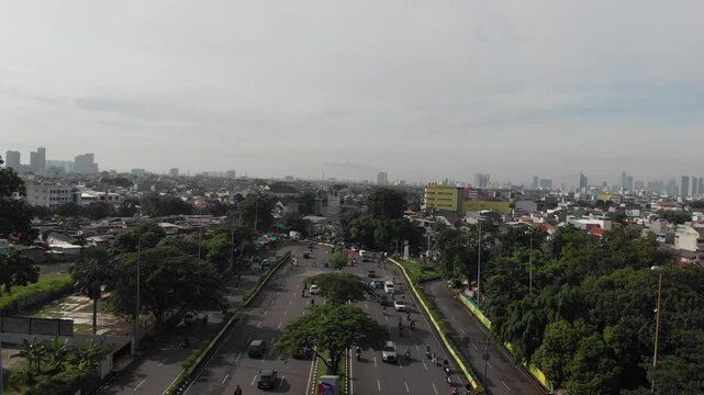 Aerial Footage Zoom Out Mountains at Jakarta Kemayoran and Busy Roads with Ondel-Ondel Jakarta Icon Morning and Cloudy Sky
