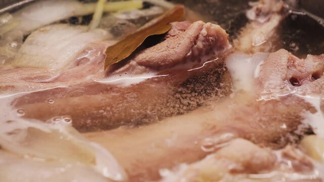 Boiling bubbling turkey soup with vegetables and spices close-up footage. High quality 4k footage
