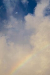 a cloud forms a cumulus with a moon and a rainbow