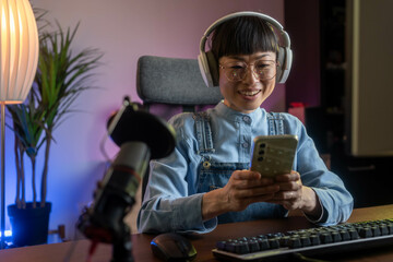 Making selfie, celebrating victory. Female asian game streamer in casual clothes is indoors with...