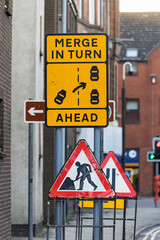 Yellow Merge in Turn Ahead and Red Triangle Road Works Signs for Temporary Traffic Control