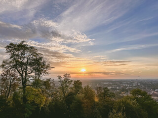 The sky is blue with a few clouds and the sun is setting