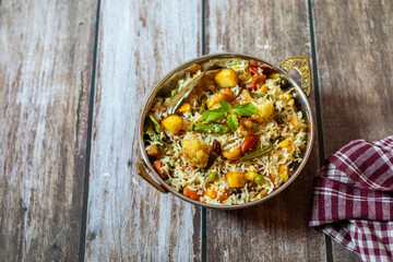 Navratan Pulao is a fragrant, colorful rice dish cooked with mixed vegetables, dry fruits, and aromatic spices, often served warm.