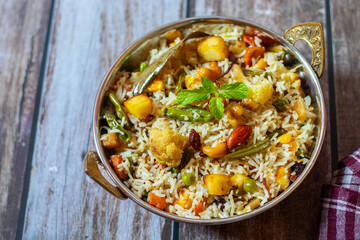 Navratan Pulao is a fragrant, colorful rice dish cooked with mixed vegetables, dry fruits, and aromatic spices, often served warm.