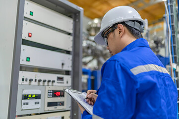 Electrical engineer man checking voltage at the Power Distribution Cabinet in the control...
