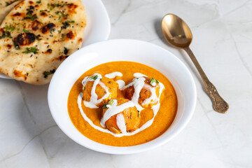 Soft, creamy malai kofta in rich, spiced tomato-cashew gravy, perfectly paired with warm, fluffy butter naan—an indulgent North Indian delight bursting with flavour and aroma.