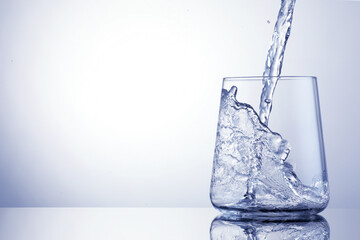 Pouring refreshing soda water into glass on light blue background, closeup. Space for text