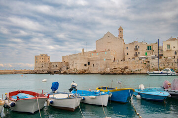 View of the Mediterranean coast and harbor with colorful fishing boats. Giovinazzo old town and the...