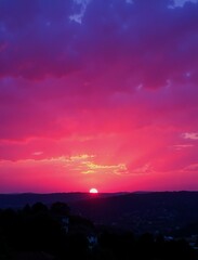 Obraz premium A breathtaking sunset paints the sky in vibrant hues of pink and red, casting a warm glow over a distant cityscape 