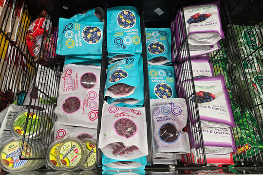 Bangsar, Malaysia &ndash; Mar 29, 2025: A selection of frozen organic raspberries, blueberries, and smoothie fruit mixes from brands like oob and Orchard Gold in a supermarket freezer section.