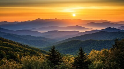 Obraz premium Vibrant sunset over layered mountain ranges, showcasing diverse foliage and tranquil atmosphere.
